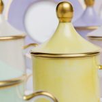 Light blue cylindrical coffee cup with saucer and lid